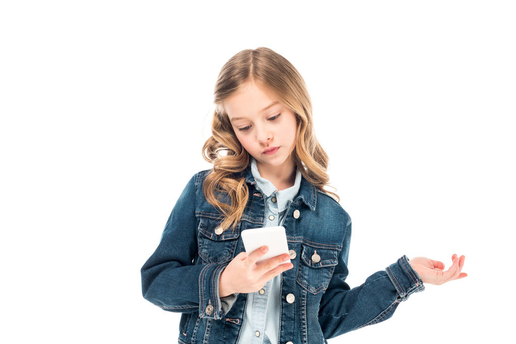 Konzentriertes Kind in Jeansjacke mit Smartphone - Foto, Bild