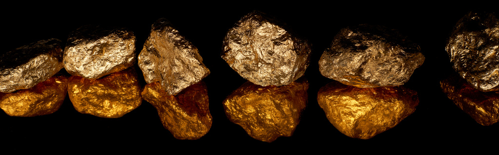 panoramische Aufnahme von goldglänzenden Steinen in Reihe mit Reflexion isoliert auf schwarz - Foto, Bild