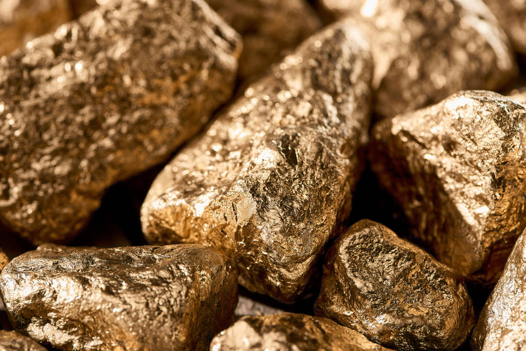 Close-up weergave van gouden getextureerde glanzende stenen bij daglicht - Foto, afbeelding