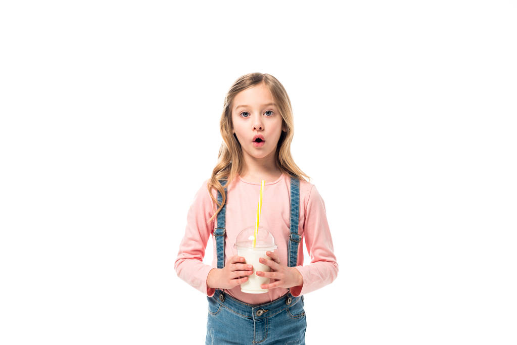 Frontansicht eines schockierten Kindes mit Milchshake isoliert auf weiß - Foto, Bild