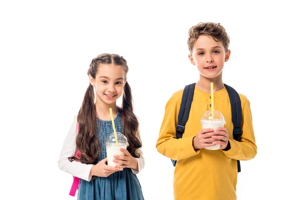 двое счастливых детей, держащих молочные коктейли и смотрящих в камеру, изолированную на белом
 - Фото, изображение
