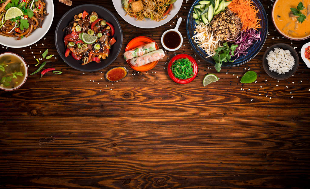 asiatisches Essen Hintergrund mit verschiedenen Zutaten auf rustikalem Holztisch, Draufsicht. - Foto, Bild