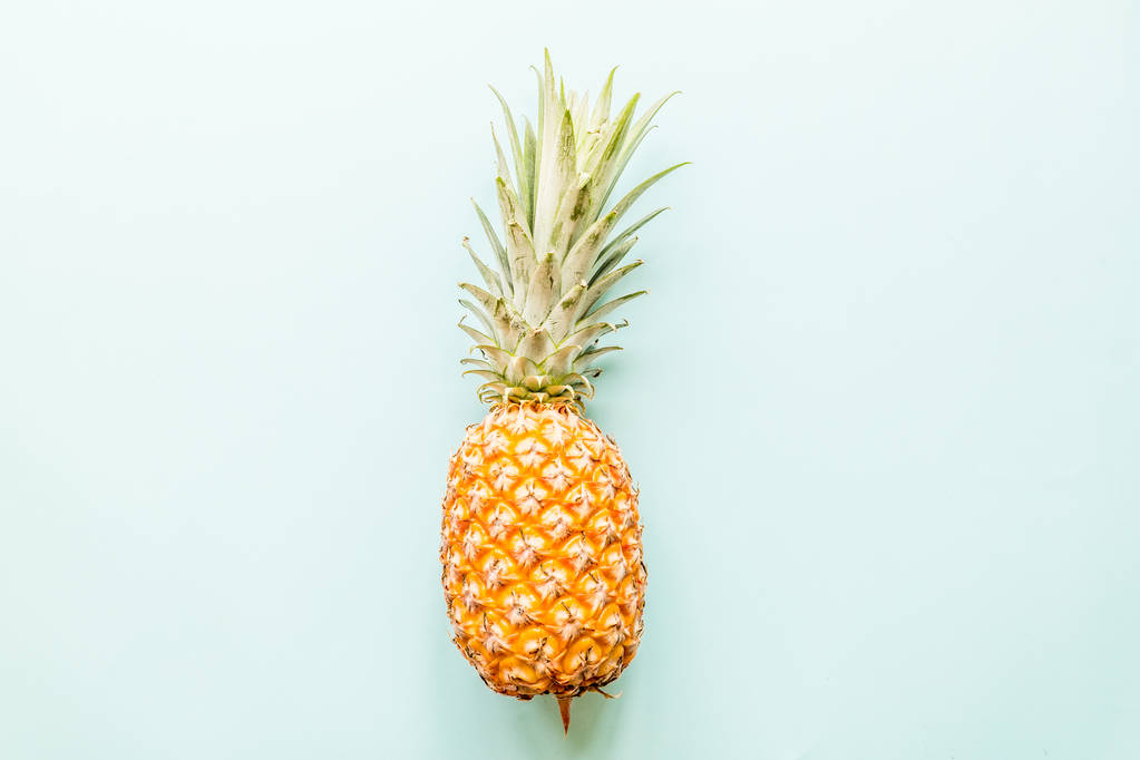 Čerstvý ananas ležící na modrém pozadí. Pohled shora. Plochá koncepce - Fotografie, Obrázek
