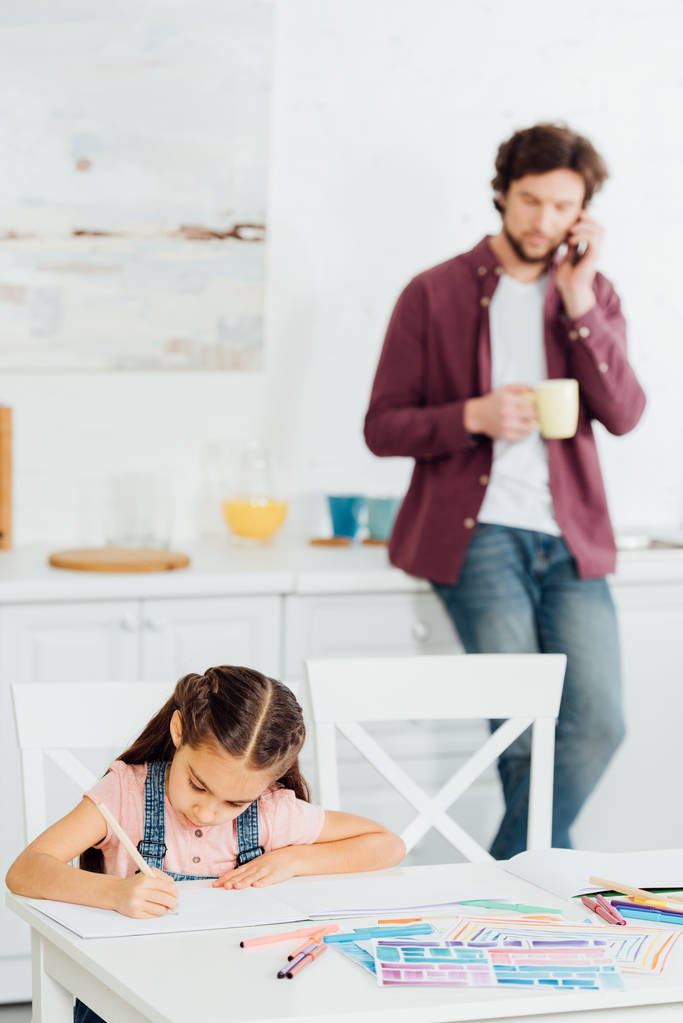 akıllı telefon ve bardak tutan konuşma baba yakınında kağıt üzerinde çizim sevimli çocuk seçici odak  - Fotoğraf, Görsel