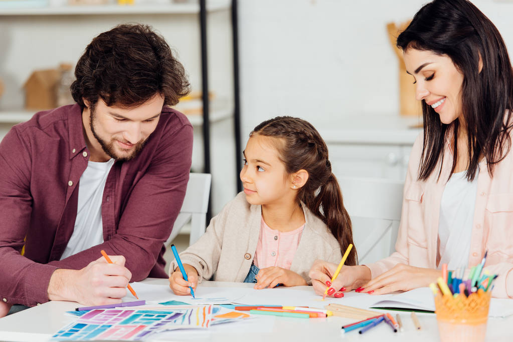 веселый ребенок смотрит на отца рисунок с цветным карандашом дома
  - Фото, изображение