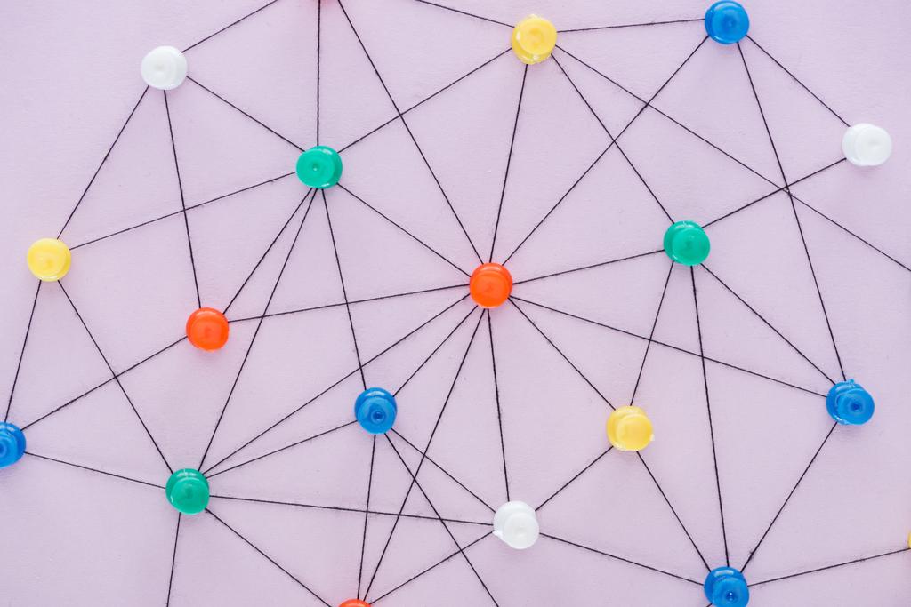 Κορυφαία όψη των πινέζες που συνδέονται με χορδές απομονωμένα σε ροζ, έννοια δικτύου - Φωτογραφία, εικόνα