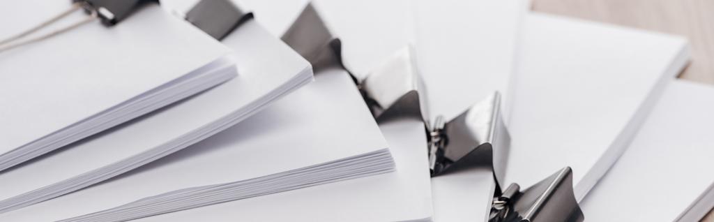 panoramic shot of stacks of blank paper with metal binder clips  - Photo, Image