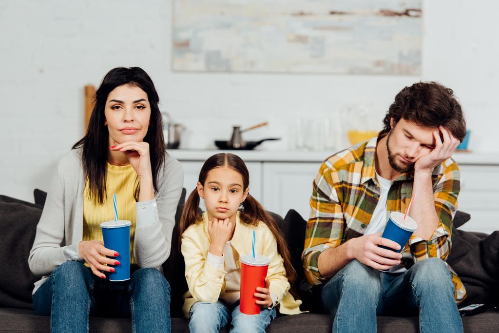 нудна сім'я тримає одноразові чашки під час перегляду фільму вдома
  - Фото, зображення