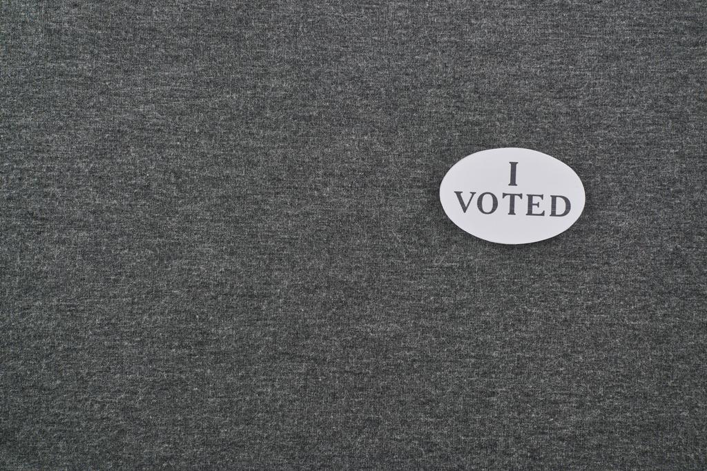 top view of badge with i voted lettering on textured background - Photo, Image