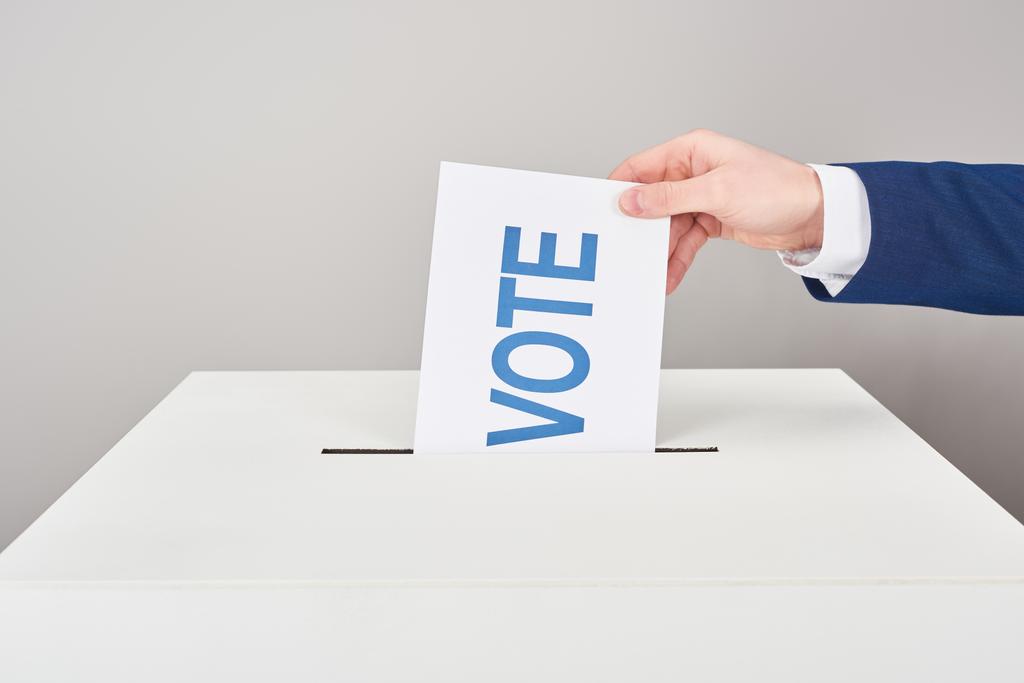 vista parziale dell'uomo che mette il voto in scatola su sfondo grigio
 - Foto, immagini