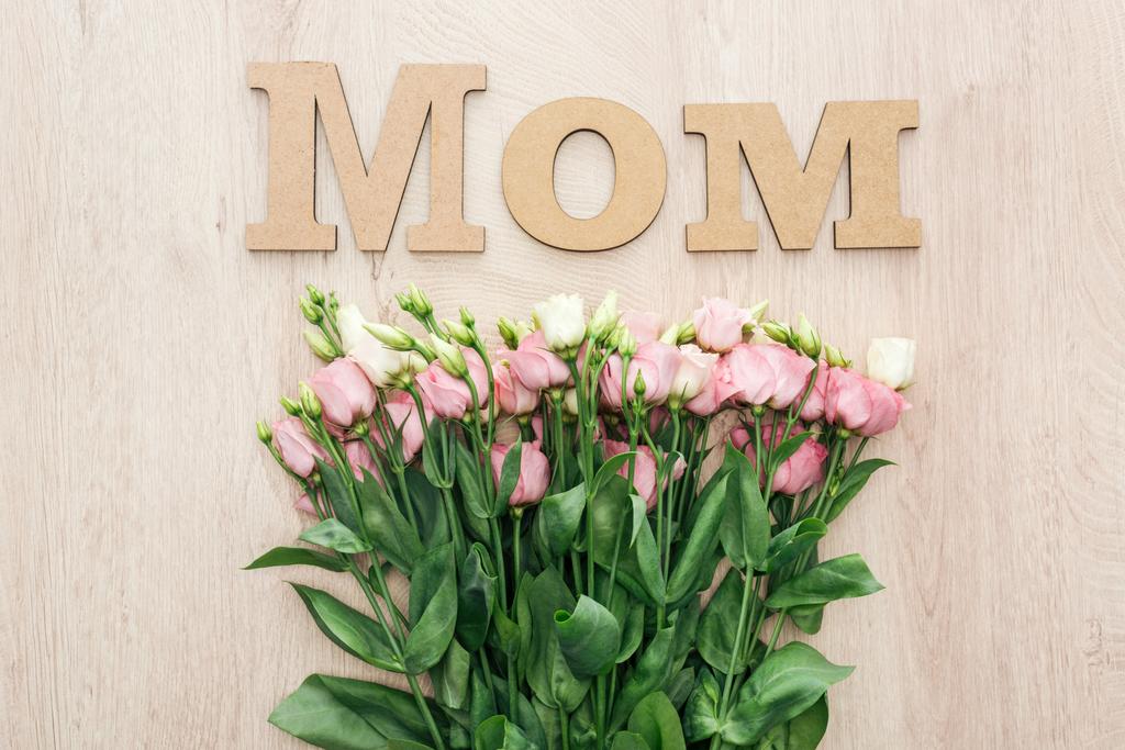 вид зверху на квіти еустоми з дерев'яною мамою слово на столі
 - Фото, зображення