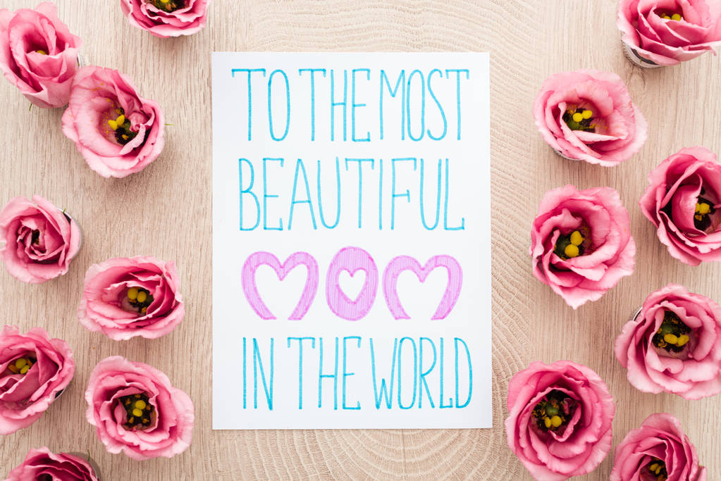 κορυφή θέα του ροζ ευστόμα λουλούδια και την κάρτα με την πιο όμορφη μαμά στον κόσμο γράμματα στο τραπέζι - Φωτογραφία, εικόνα