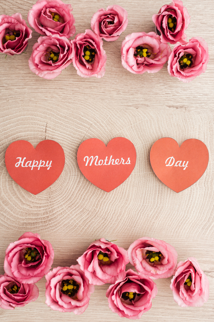 vista dall'alto di carte a forma di cuore con felici mamme giorno scrittura e fiori di eustoma su tavolo di legno
 - Foto, immagini