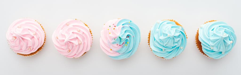 plano panorámico de sabrosos pastelitos de colores con aspersiones aisladas en blanco
 - Foto, imagen