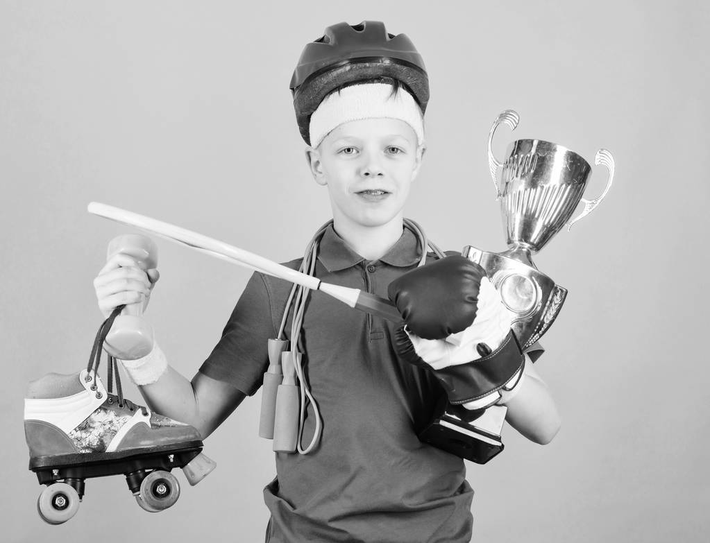 Athlète réussi garçon équipement de sport saut corde gant de boxe raquette de tennis roller skate et gobelet d'or. Succès et récompense. Le succès dans le sport. Fiers du succès obtenu. Réussir en tout
 - Photo, image