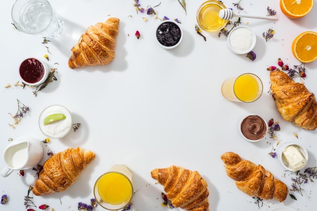 top view of tasty croissants near bowls with jam and drinks on white  - Photo, Image
