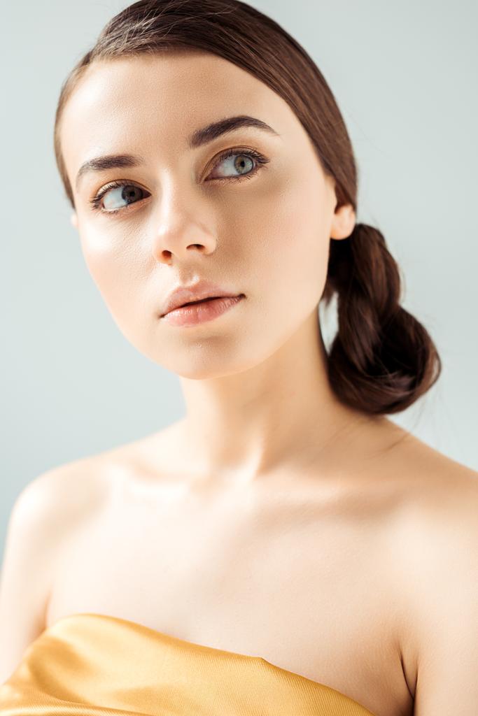 portrait of young woman with shiny lips and golden eye shadow isolated on grey - Photo, Image
