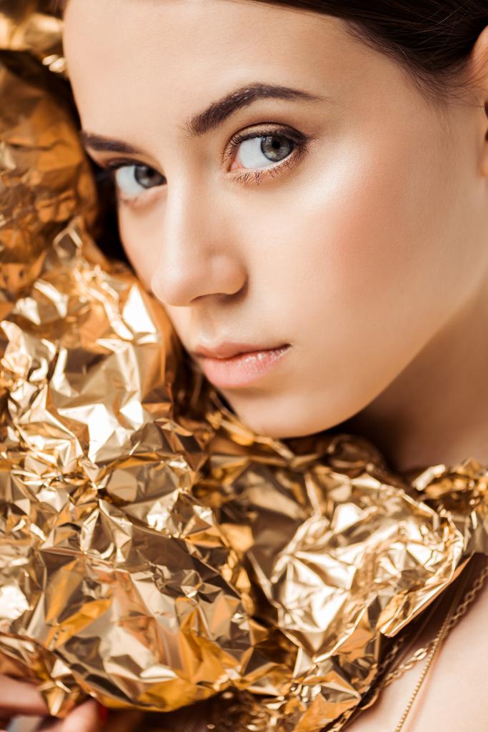 portrét mladé ženy s lesklým make-upem blízko zlaté fólie na kameře - Fotografie, Obrázek