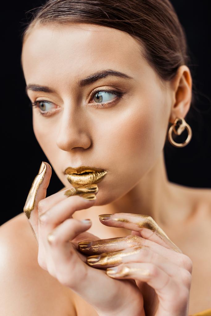 young naked woman with golden makeup and golden paint on fingers isolated on black - Photo, Image