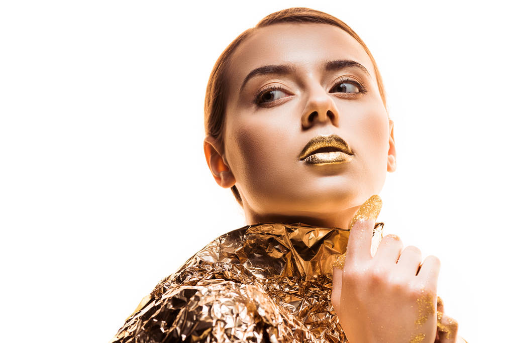 young woman with golden lips in golden foil looking away isolated on white - Photo, Image