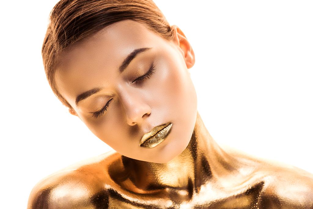 young naked woman with closed eyes painted in golden isolated on white - Photo, Image
