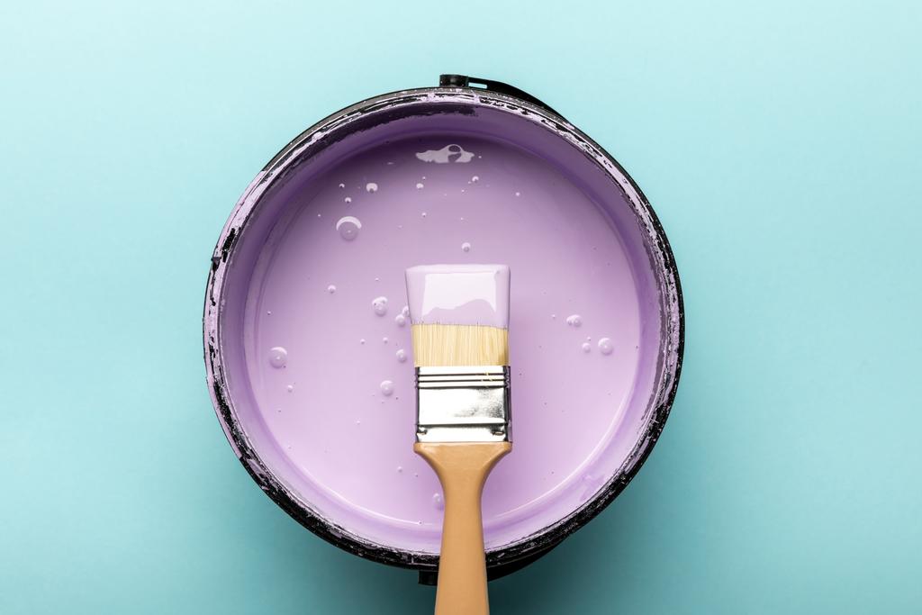 top view of bucket with purple paint and brush on blue - Photo, Image