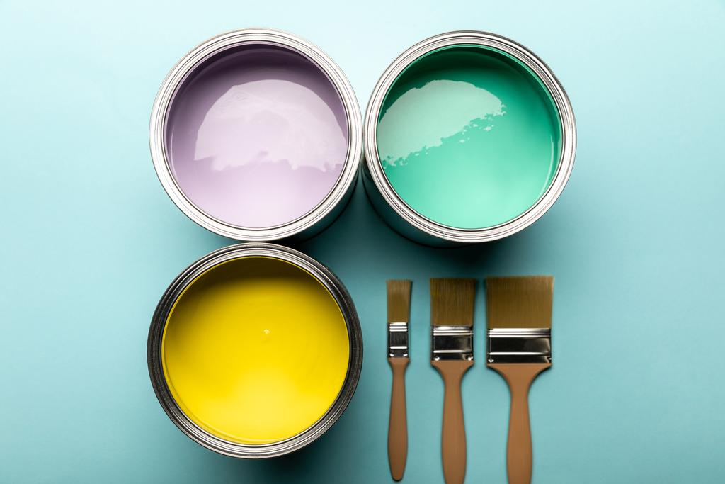 mavi yüzeyüzerinde boya lar ve fırçalar ile renk tinlerinin üst görünümü - Fotoğraf, Görsel