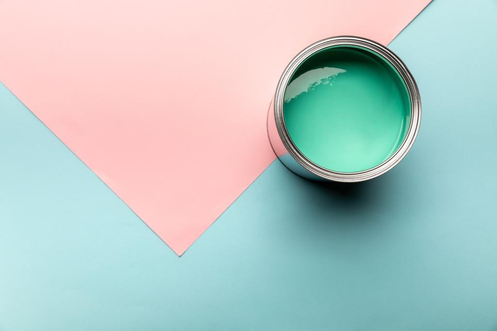 vista superior de la lata con pintura verde sobre la superficie azul y rosa
 - Foto, imagen