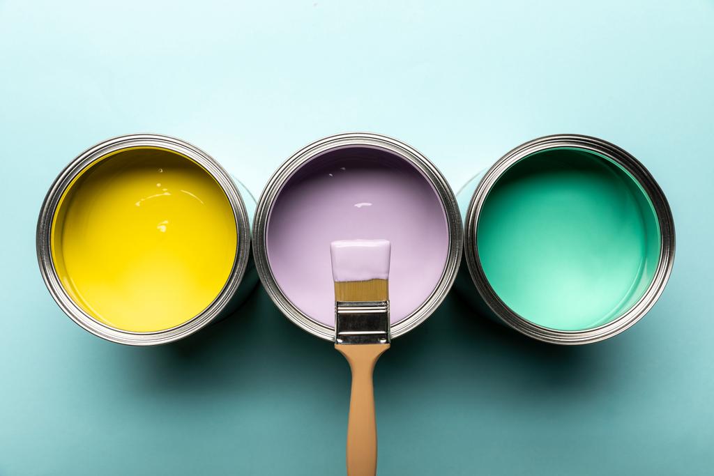 mavi yüzeyüzerinde boya ve fırça ile üç renk üst görünümü - Fotoğraf, Görsel