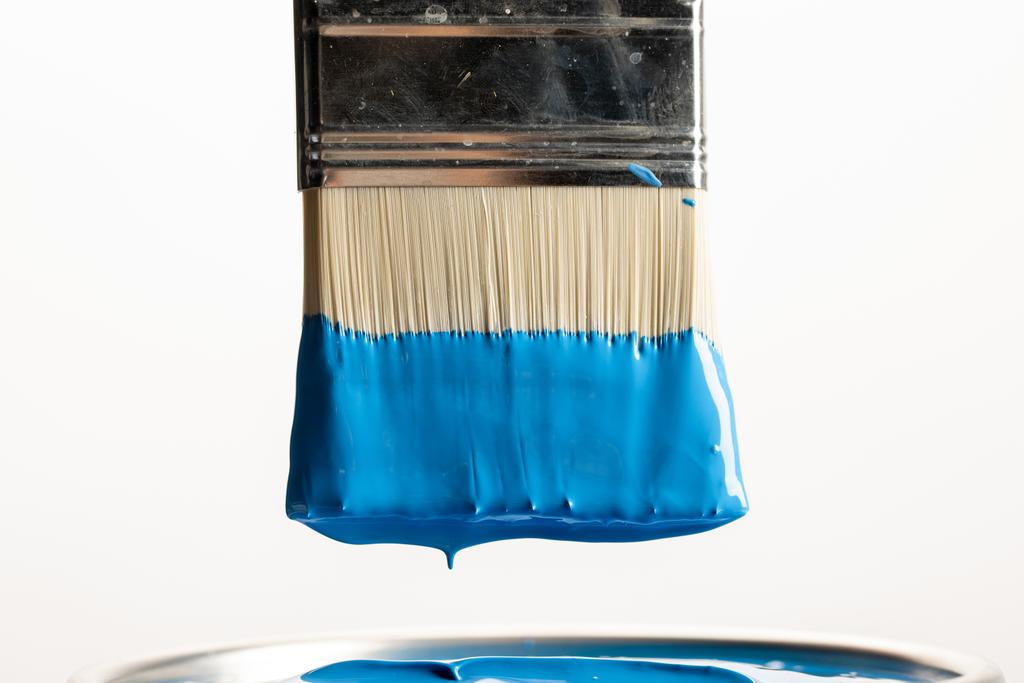 close-upweergave van penseel met blauwe verf over kan op wit worden geïsoleerd - Foto, afbeelding