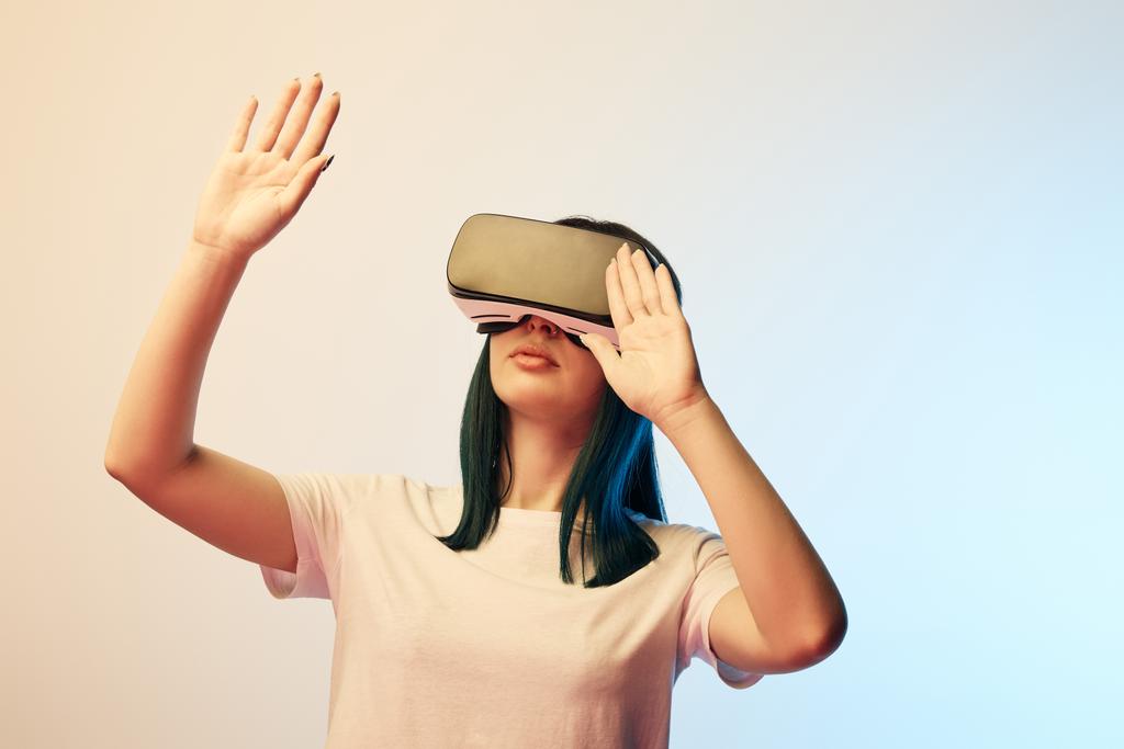 jeune femme portant casque de réalité virtuelle et geste sur beige et bleu
  - Photo, image