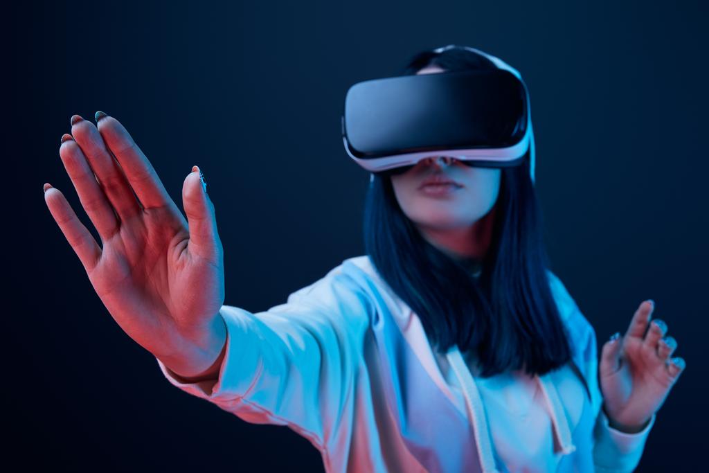 selective focus of girl gesturing while using virtual reality headset on blue  - Photo, Image
