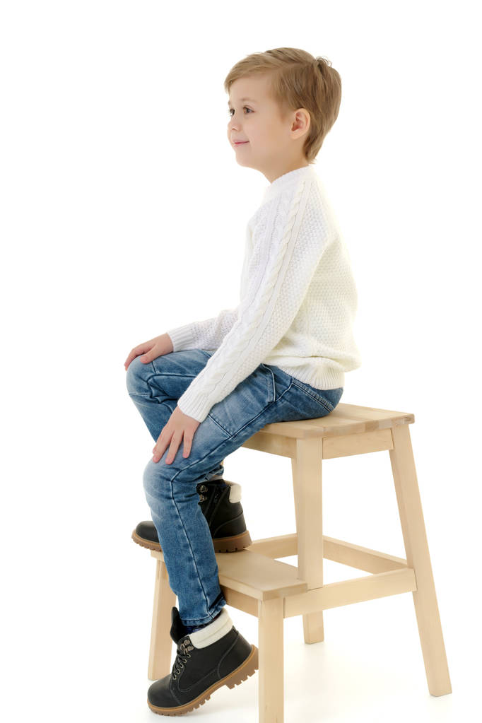 ein kleiner Junge sitzt auf einem Stuhl. - Foto, Bild