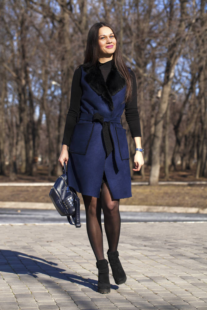 Portré egy fiatal gyönyörű nő, kék kabát egy zsák séta - Fotó, kép