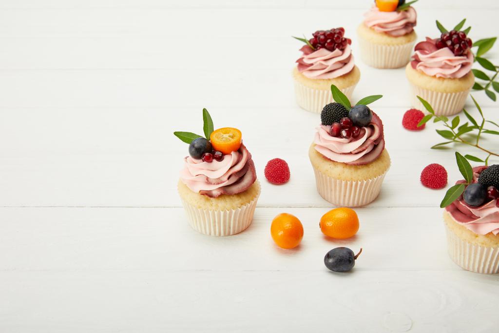 cupcakes with berries and cream on white surface - Photo, Image