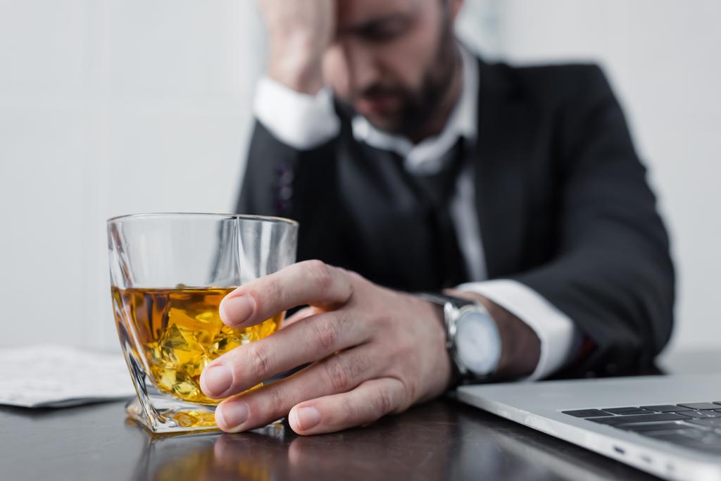 selective focus of depressed businessman holding glass of whiskey - Photo, Image