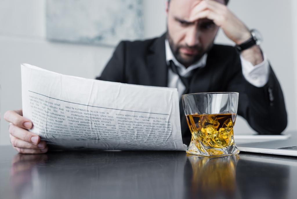 selektivní zaměření seriózní obchodník čtení novin u skleničky whisky - Fotografie, Obrázek