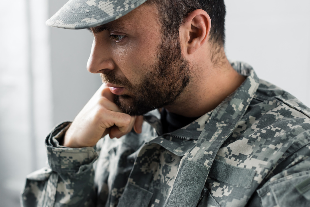 pensive bearded military man in uniform holding hand near face - Photo, Image