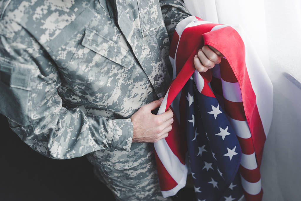 vista ritagliata dell'uomo adulto in uniforme militare con bandiera nazionale USA
 - Foto, immagini