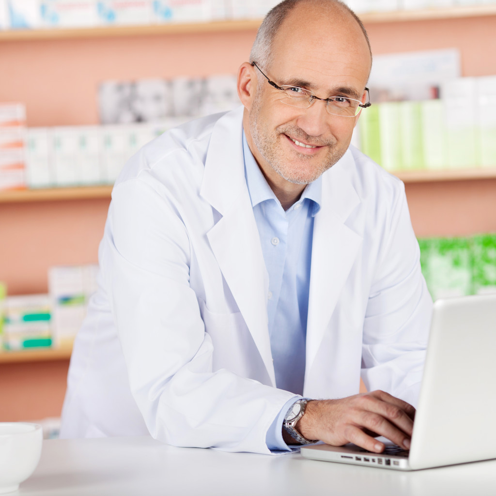 Pharmacien joyeux avec ordinateur portable
 - Photo, image