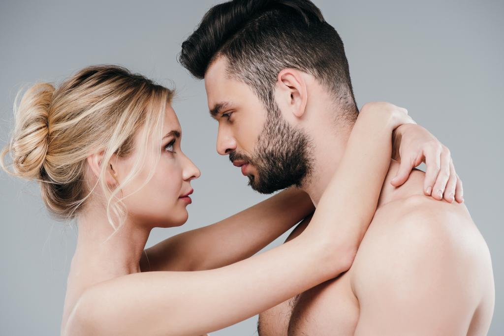 attractive nude woman hugging and looking at handsome bearded man on grey  - Photo, Image