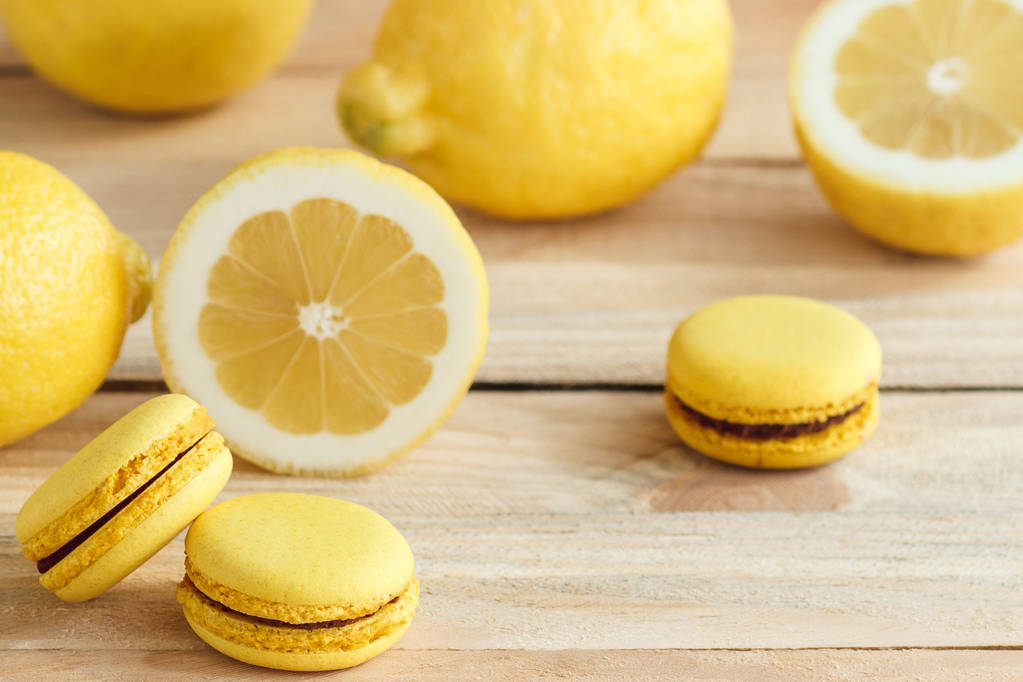 Žlutá francouzské macarons s citrony na dřevěné desce - Fotografie, Obrázek