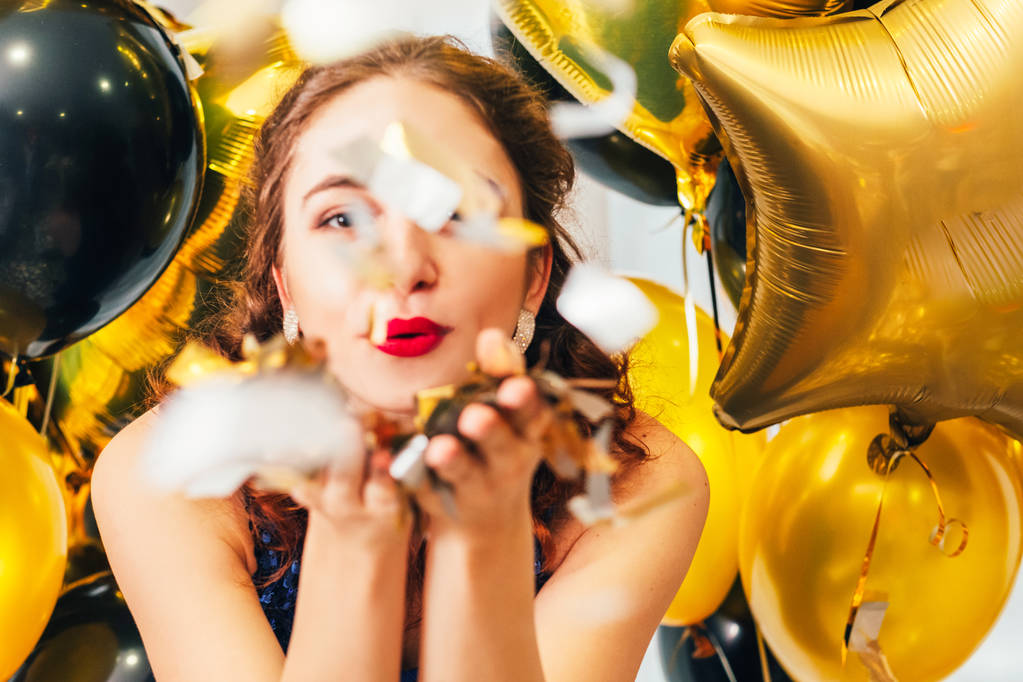 cumpleaños fiesta globos chica soplando confeti
 - Foto, Imagen