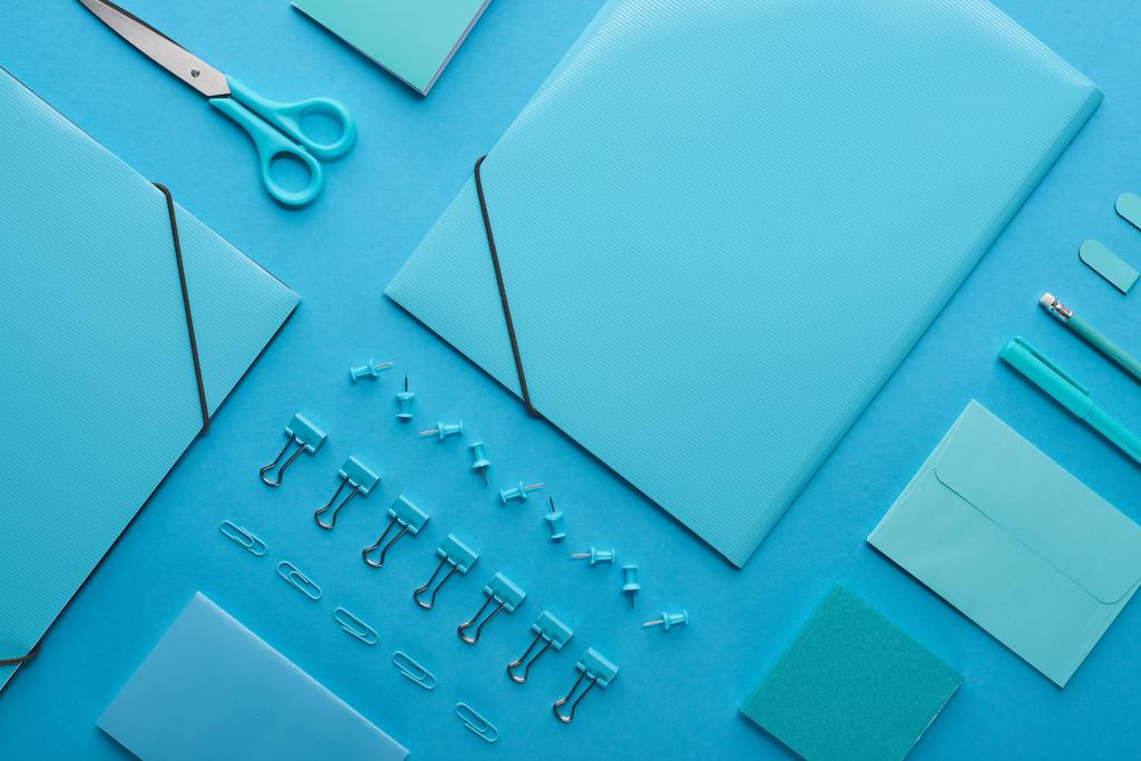 紙バインダーの平らな敷みと青で隔離された整理された文房具  - 写真・画像