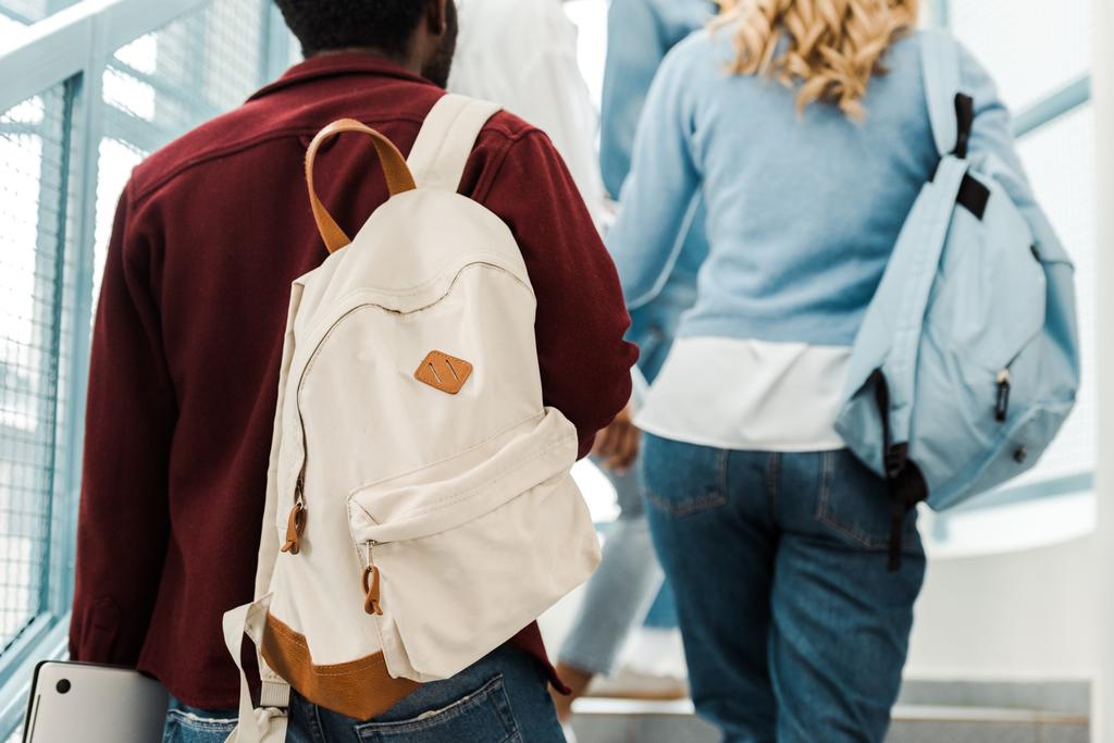 üniversitede merdivenlerde sırt çantaları ile öğrencilerin kırpılmış görünümü - Fotoğraf, Görsel