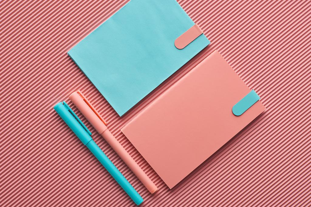 Widok z góry na ułożone długopisy i notebooki na różowo-różowy - Zdjęcie, obraz