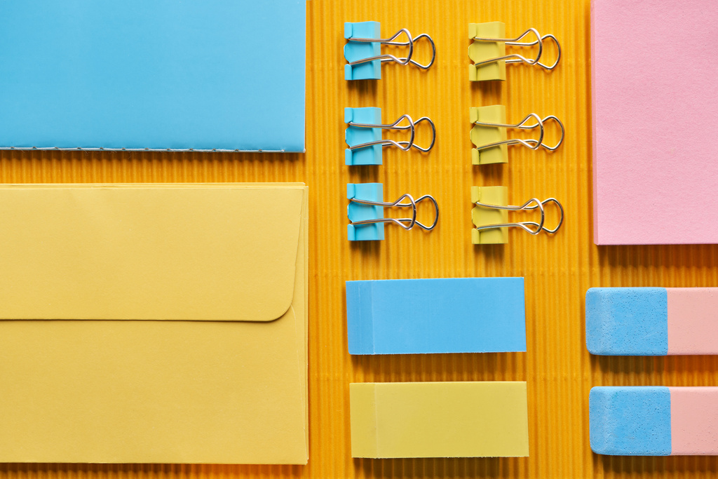 Draufsicht auf bunte Büroschreibwaren-Vorräte auf gelb - Foto, Bild