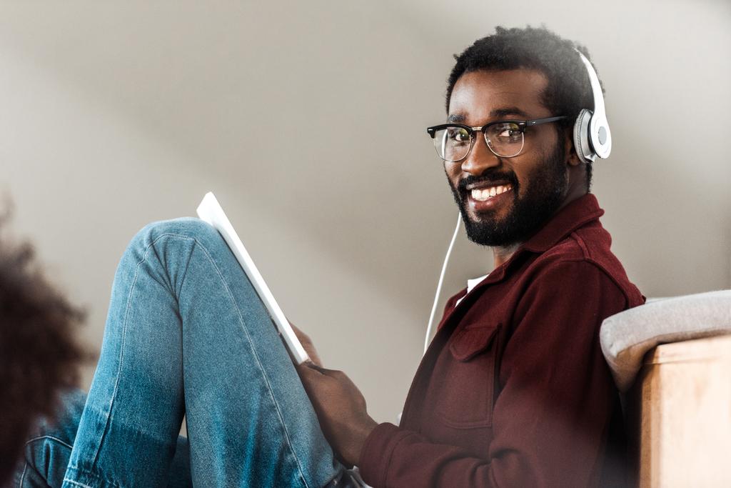 афроамериканський студент в навушниках з використанням цифрового планшета в університеті
 - Фото, зображення