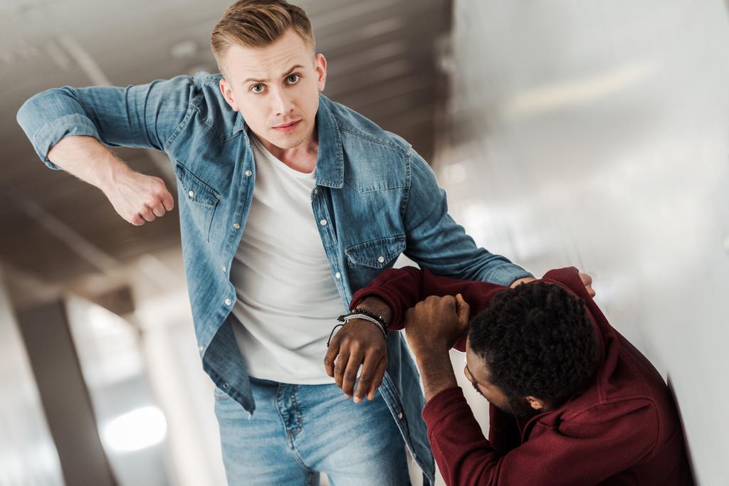 Zwei Studenten in Jeans prügeln sich auf Flur im College - Foto, Bild