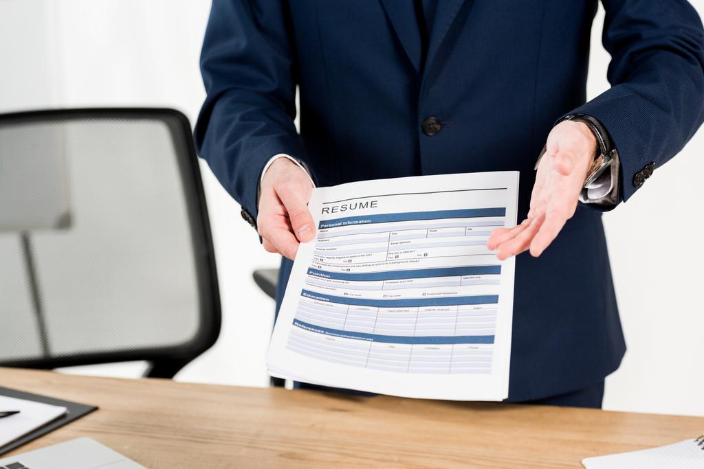 cropped view of recruiter holding resume while gesturing in office  - Photo, Image
